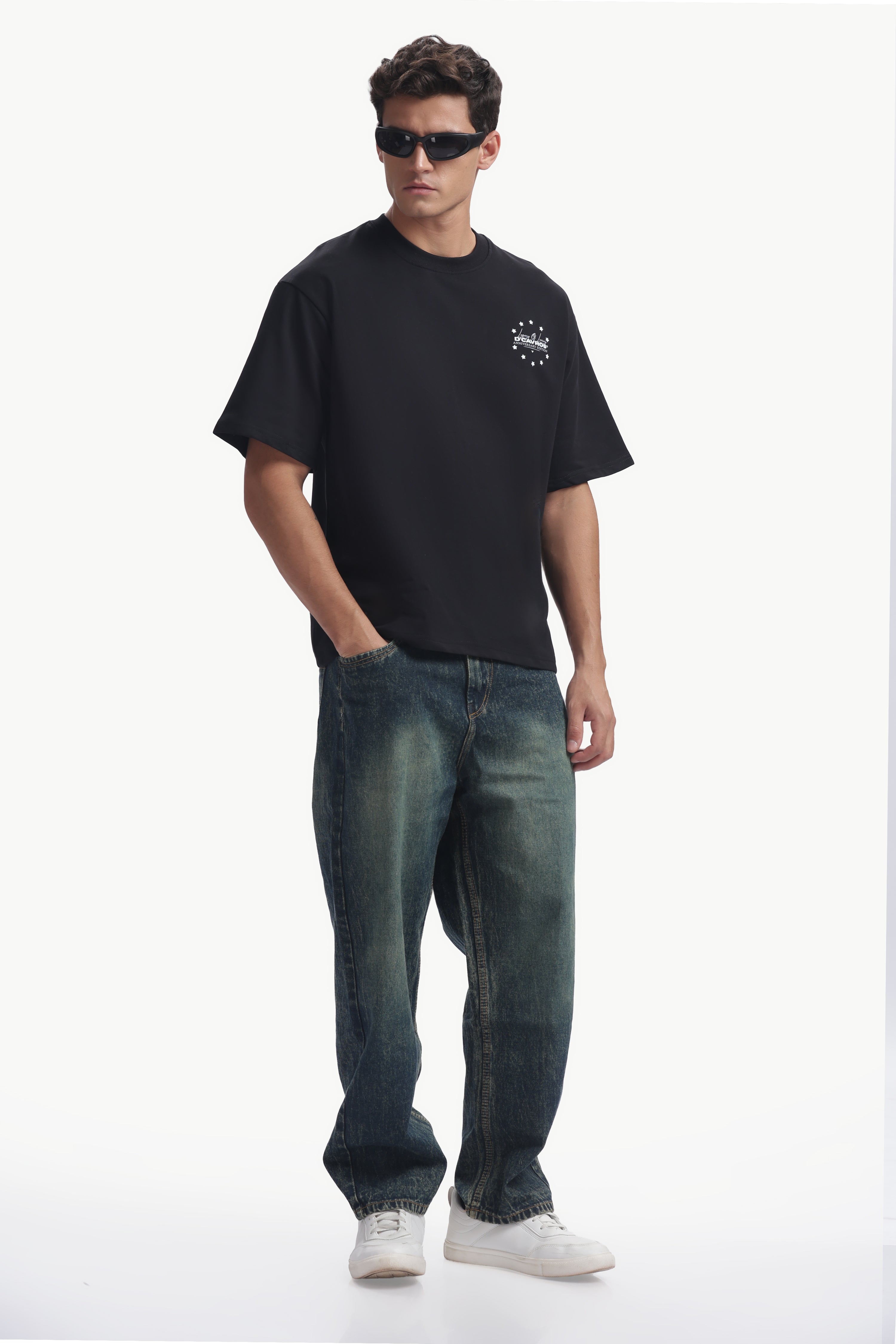 Model wearing Loose Fit Legacy Printed T-Shirt with relaxed fit, styled with baggy jeans and sunglasses.