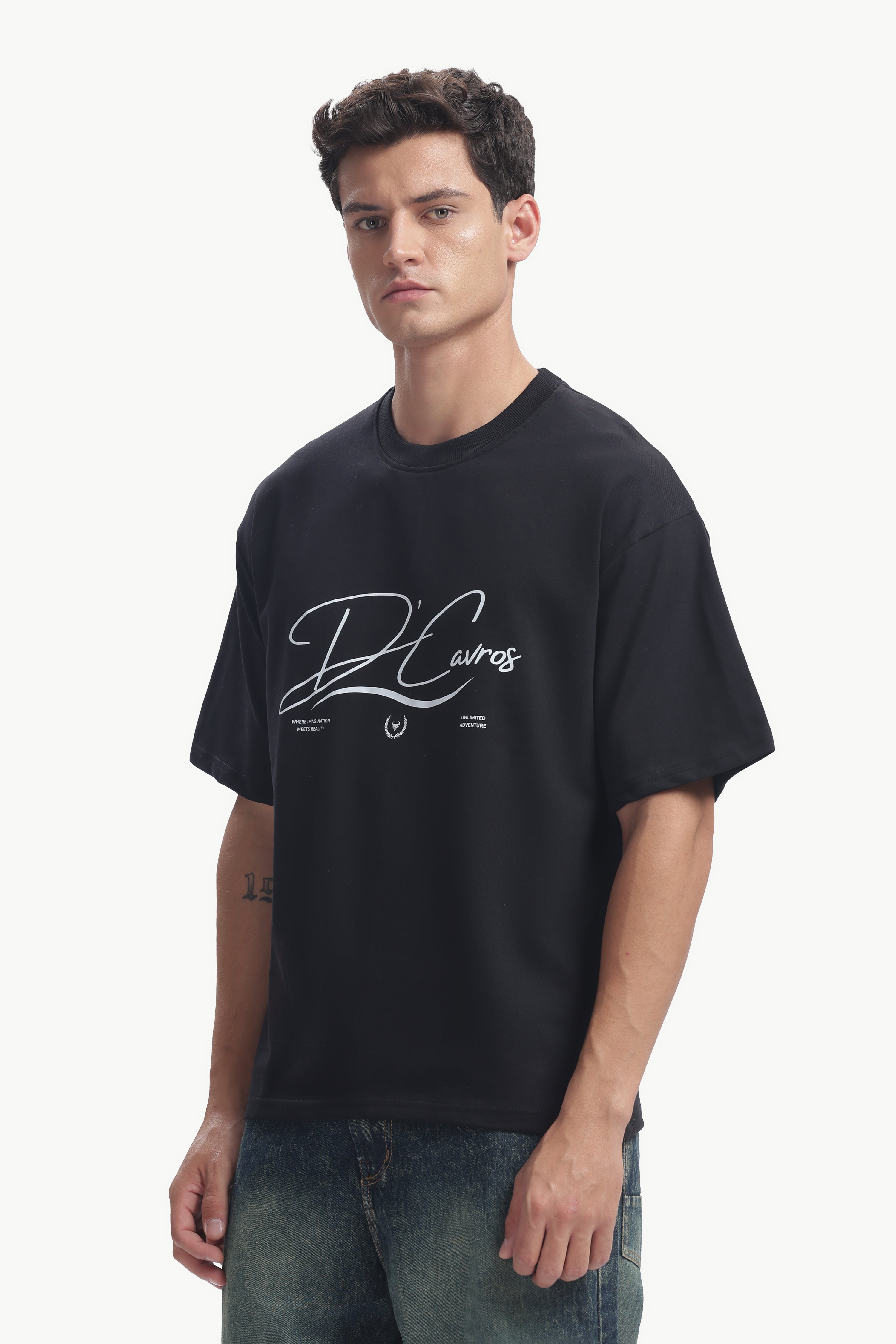 Person wearing a Community Capsule Graphics Tee featuring bold typography and a relaxed fit.