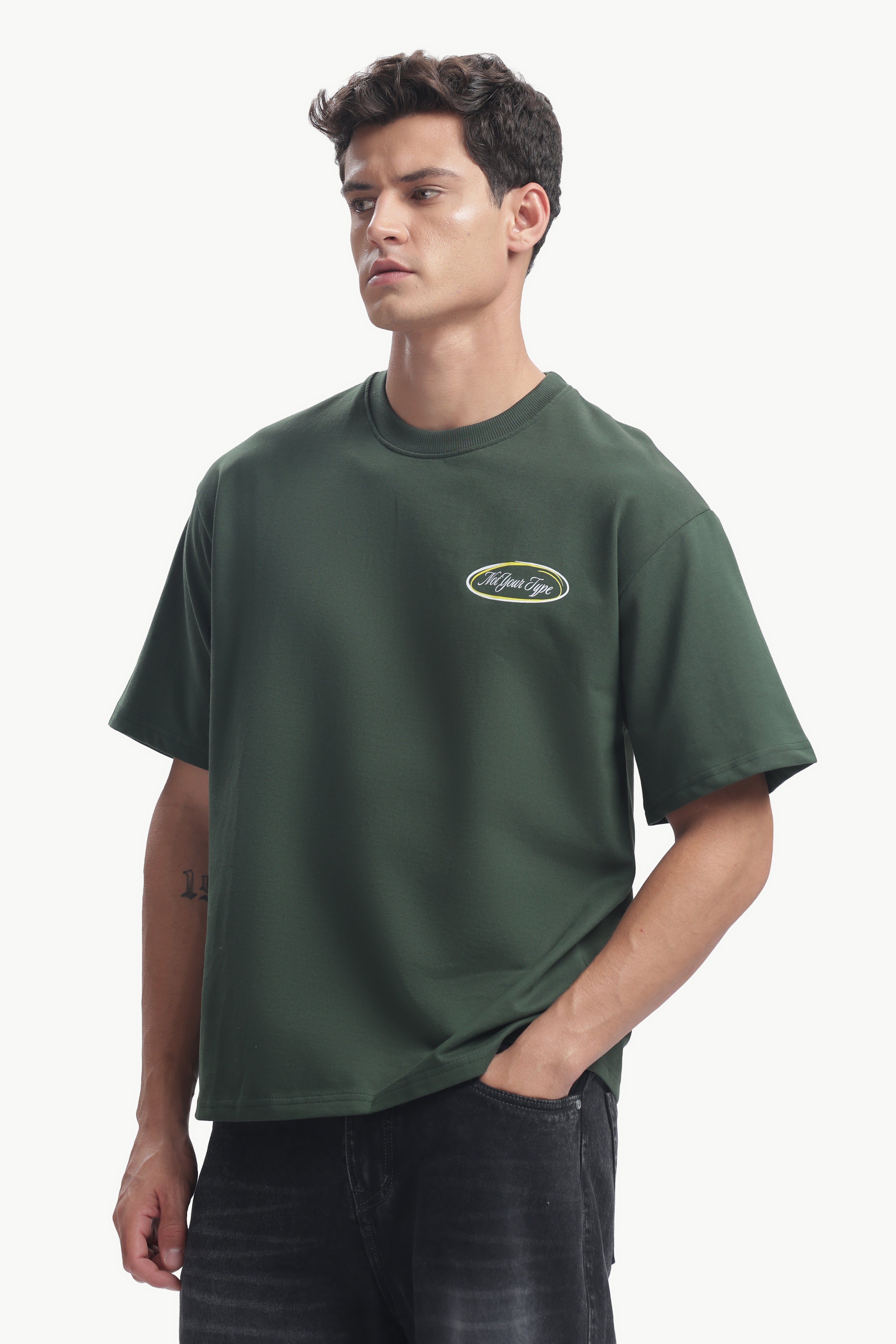 Model wearing Not Your Type Oversized Fit Tee in dark green, showcasing its relaxed silhouette and bold graphic.