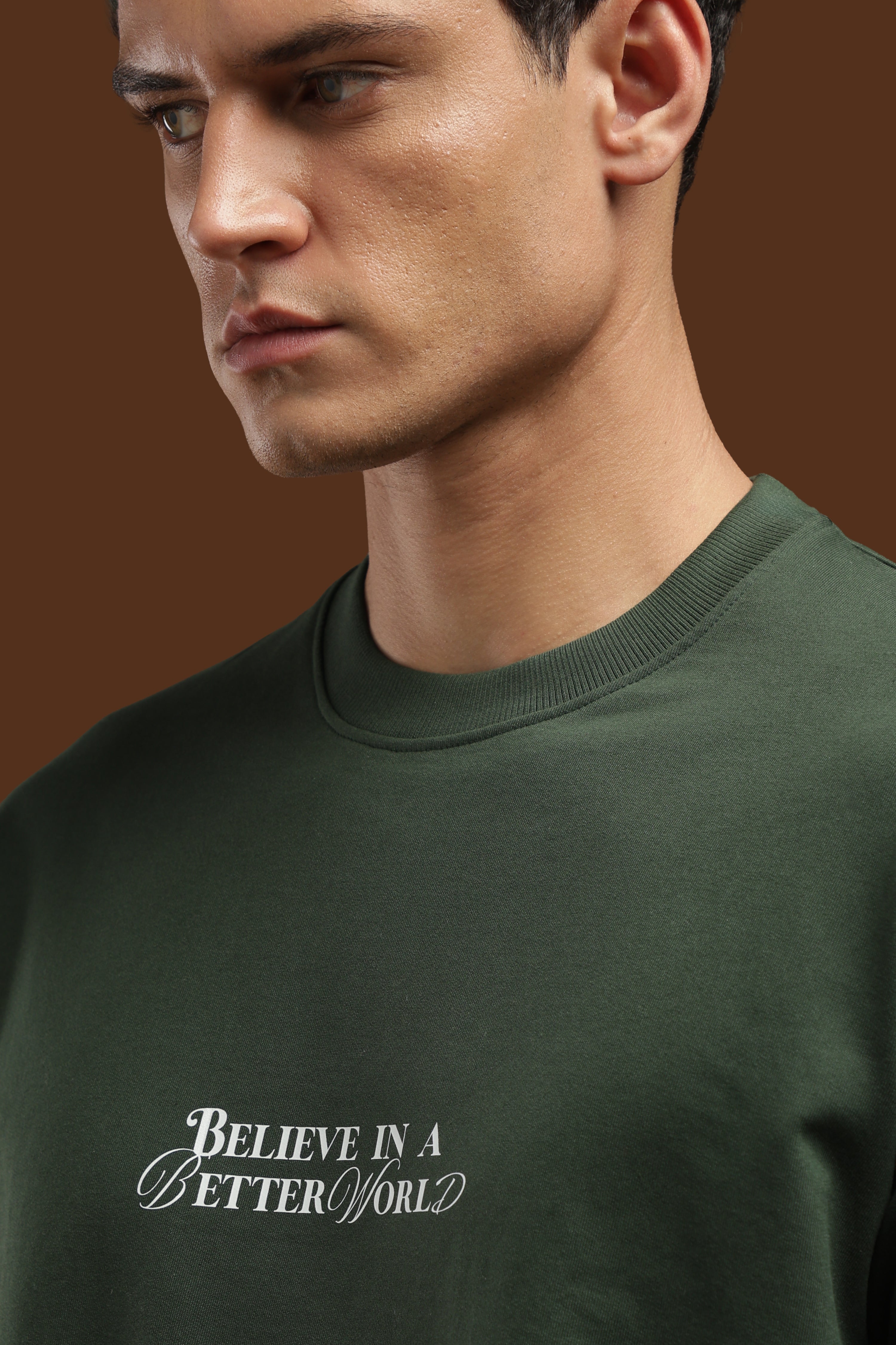 Close-up of model wearing Better World Printed Oversized T-Shirt with 'Believe in a Better World' graphic.