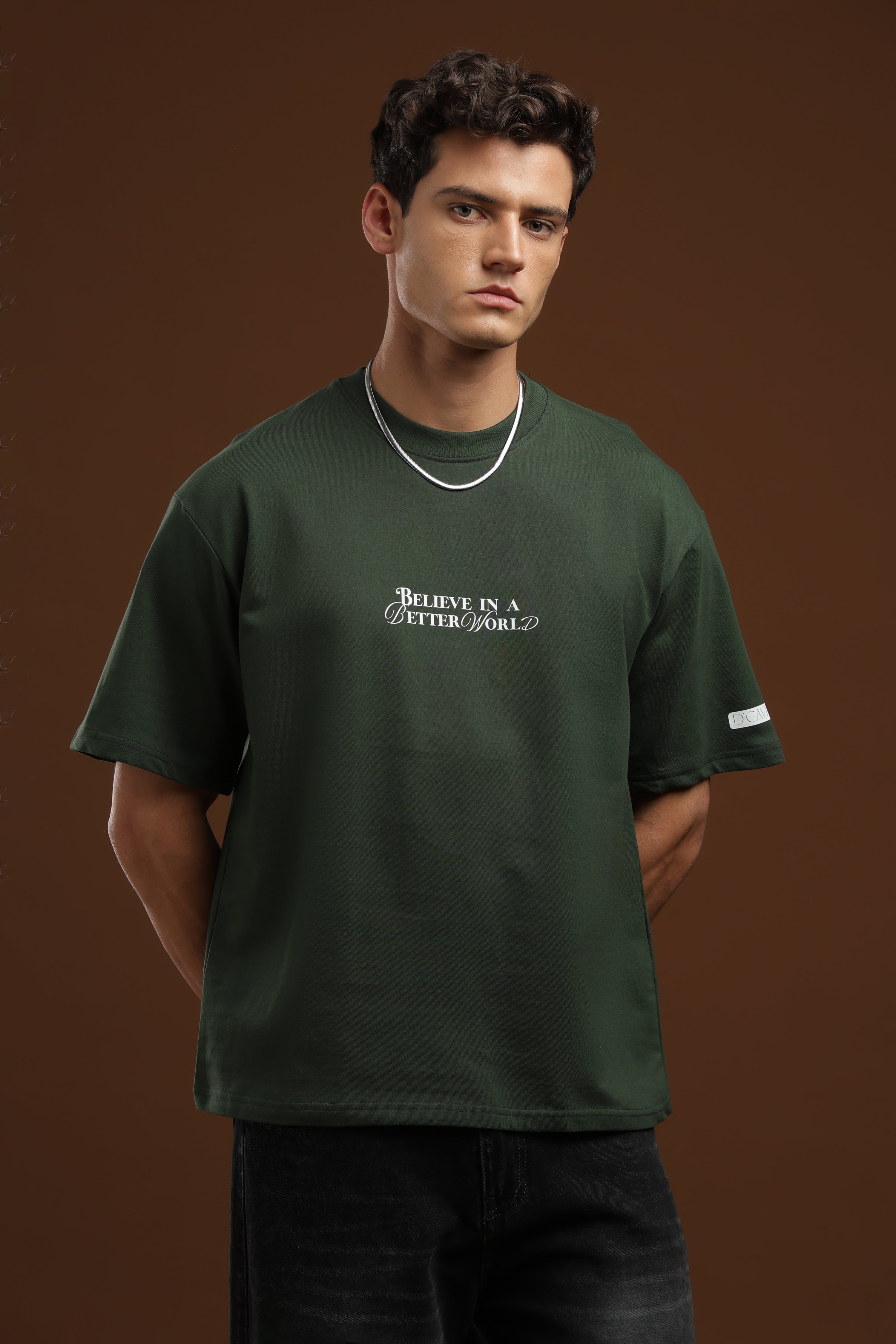 Man wearing Better World Printed Oversized T-Shirt in green, featuring a bold print for relaxed style and comfort.