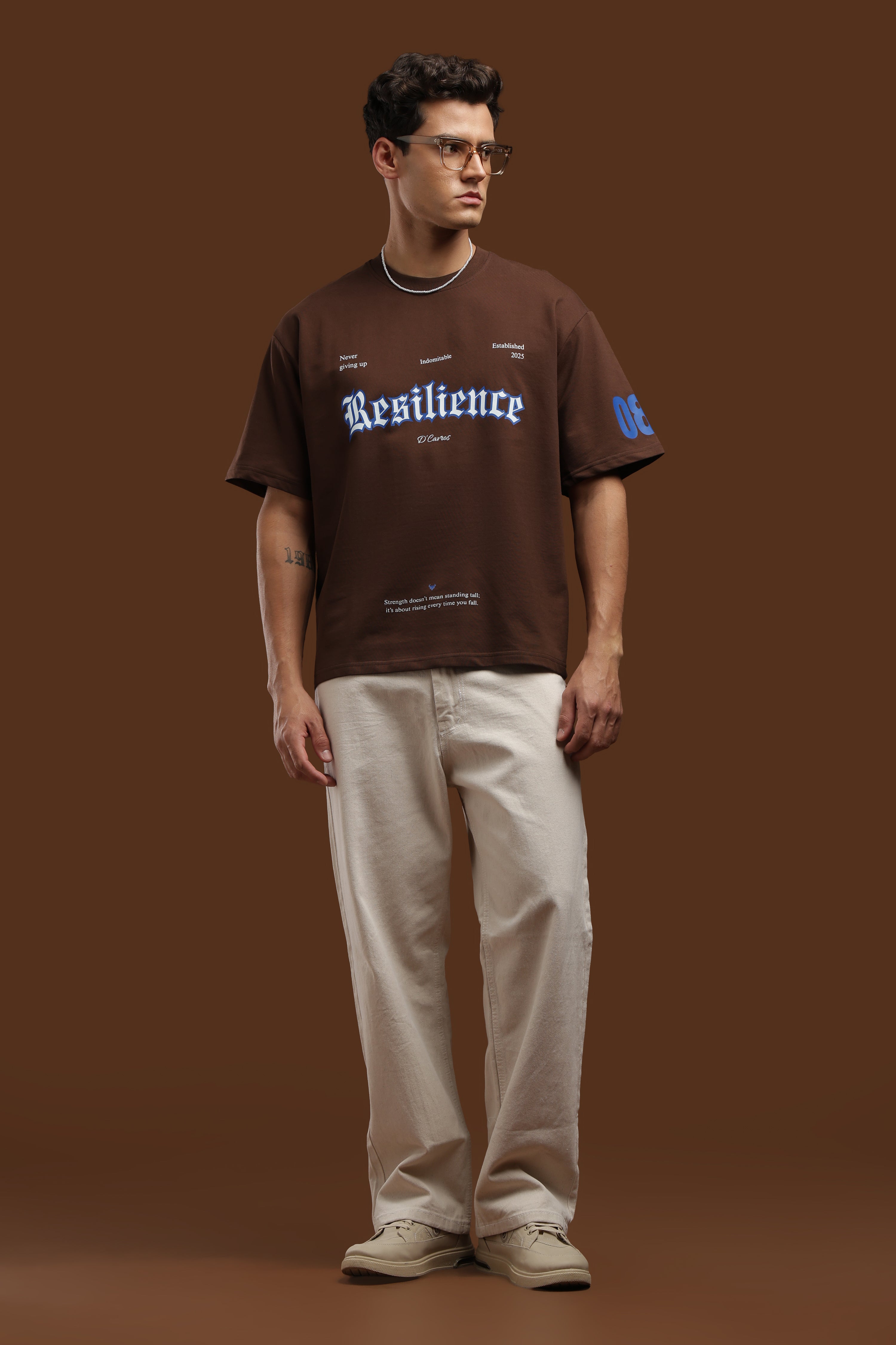 Loose Fit Resilience Printed T-Shirt in brown with bold typography, styled for casual urban wear.