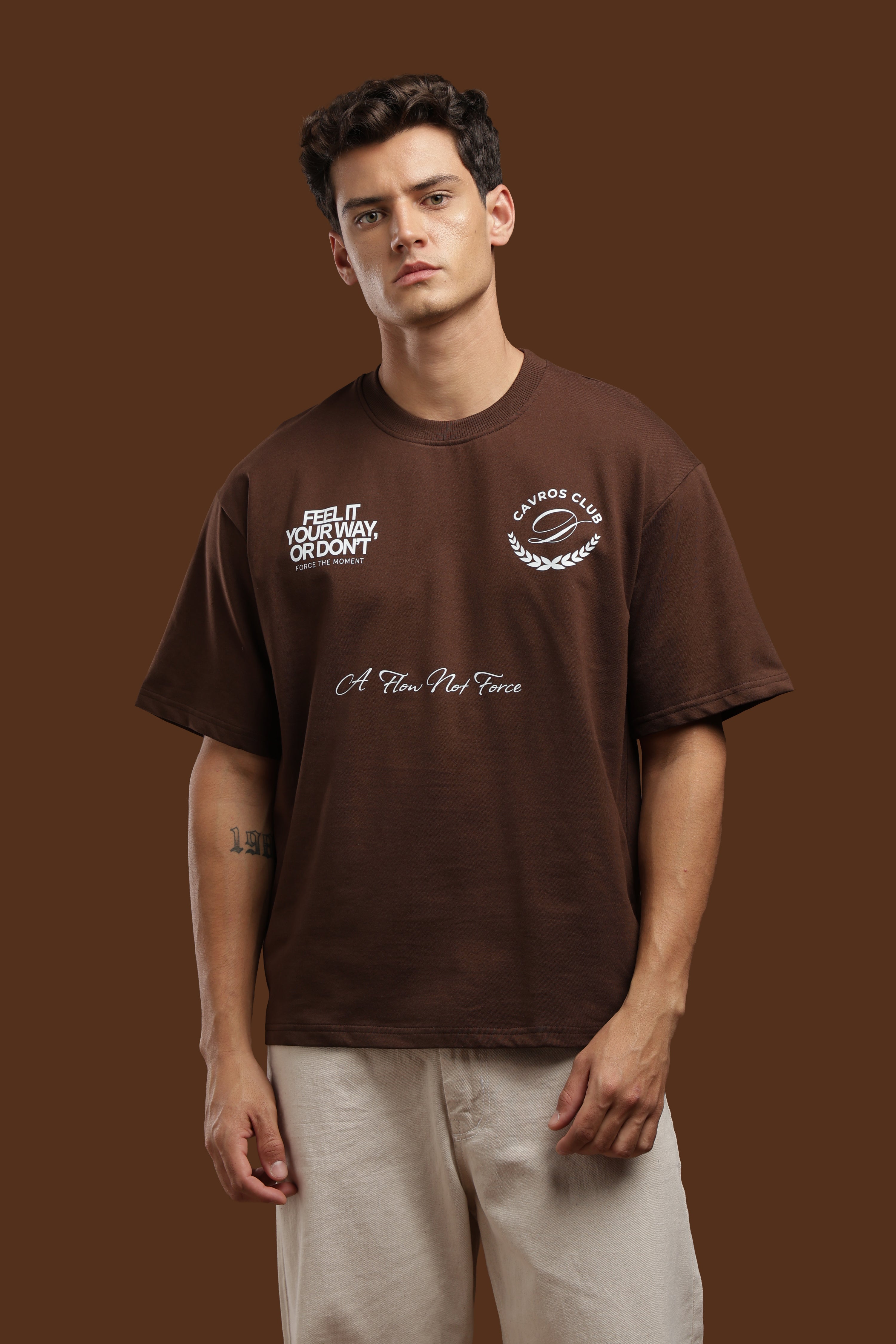 Model wearing an Oversized Fit Club Printed T-Shirt with bold graphics in dark brown color.