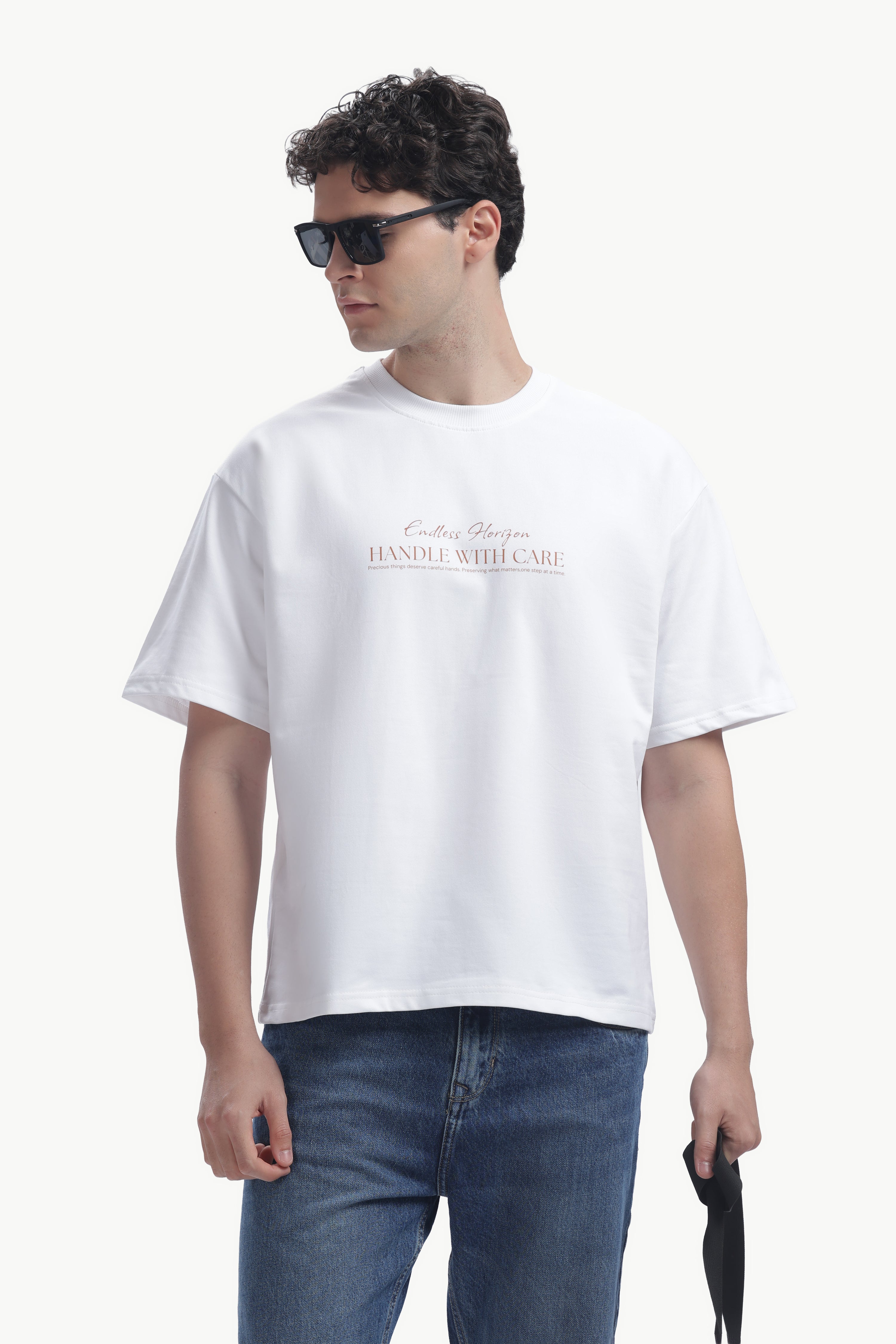 Model wearing a Vintage Horizon Printed T-Shirt, showcasing summer vibes with casual style and palm graphic.