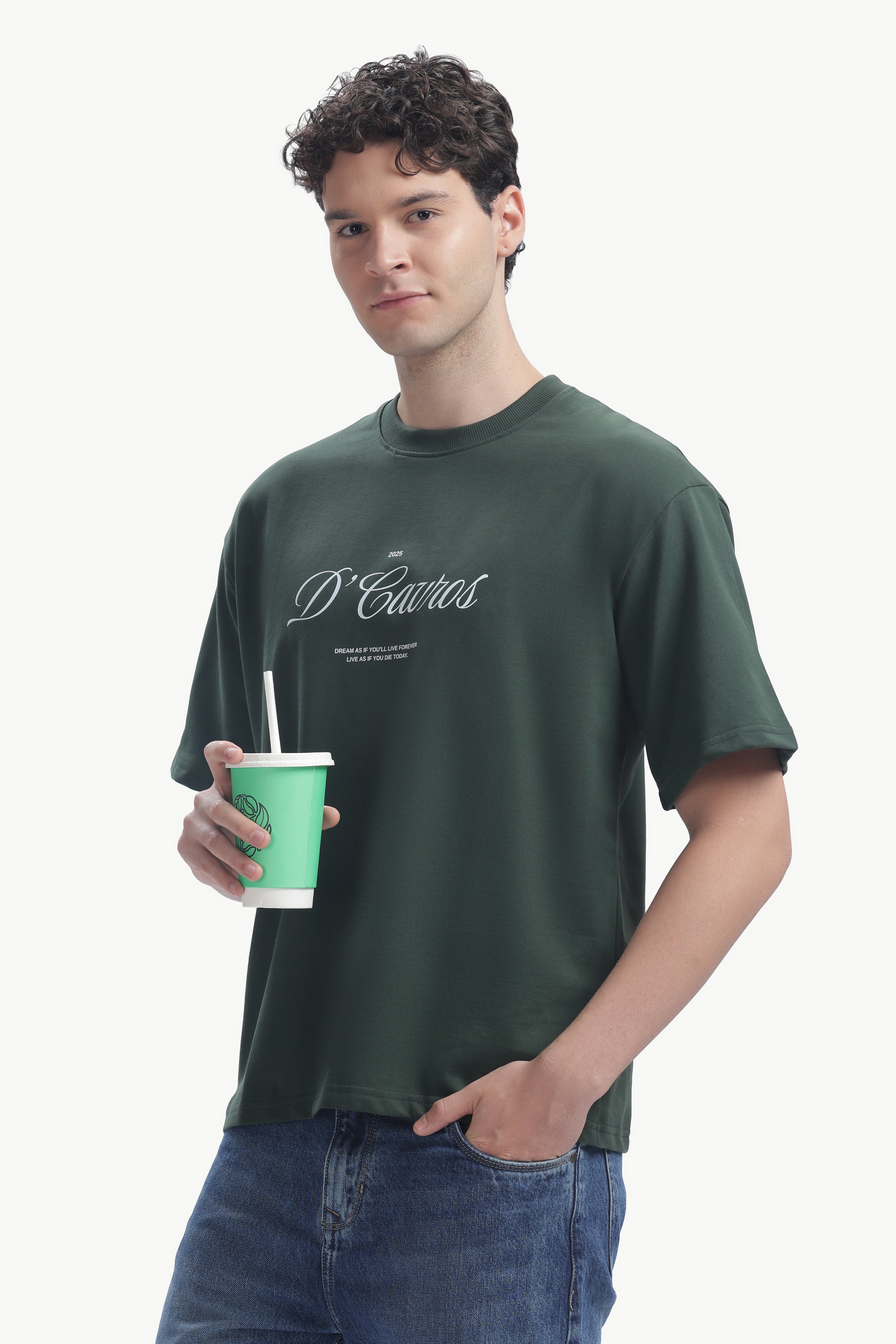 Model wearing Classic Loose Fit Typography T-Shirt in dark green, holding a cup, showcasing casual style.