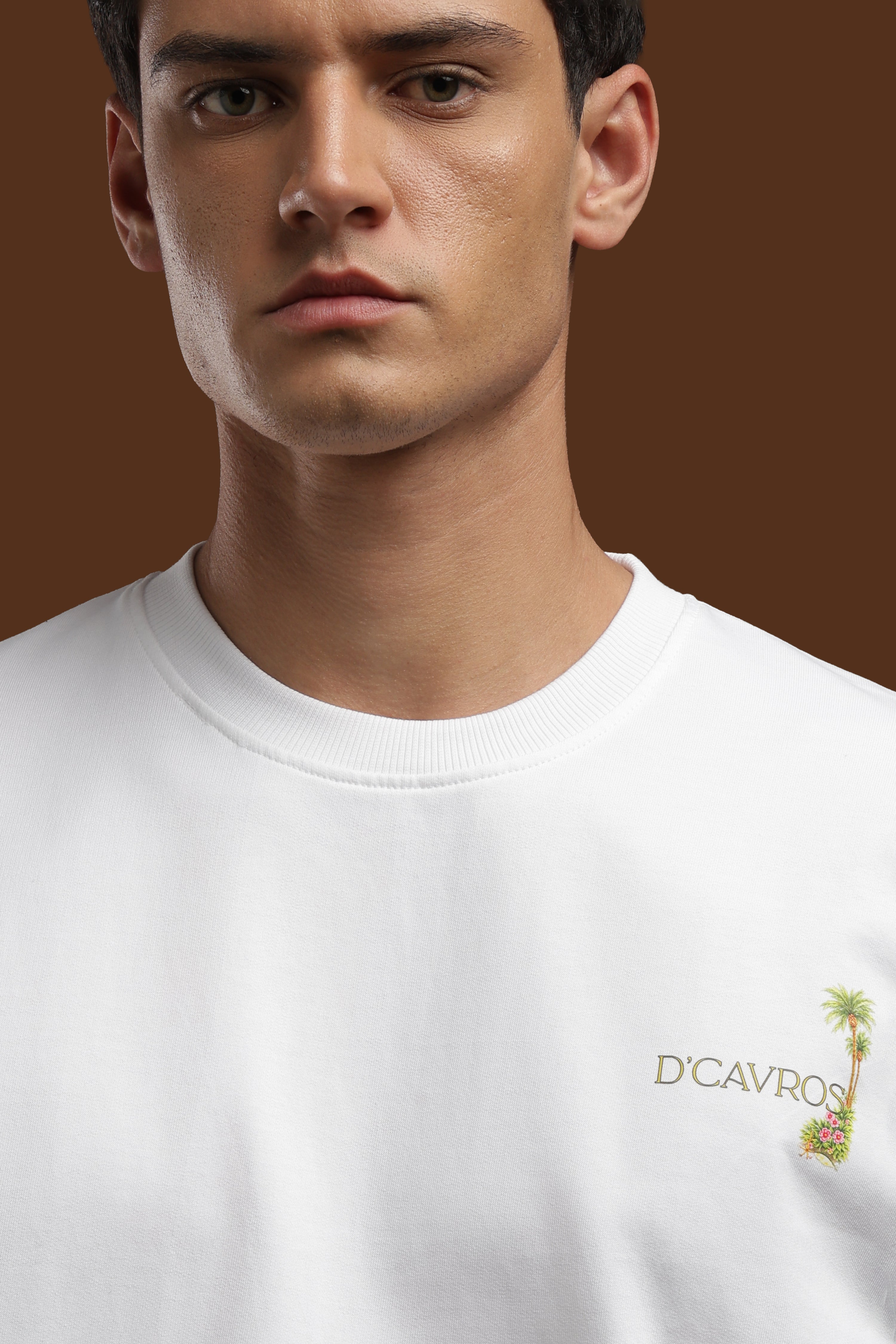 Close-up of a model wearing an Amalfi coast Oversized Fit T-Shirt with a palm tree logo.