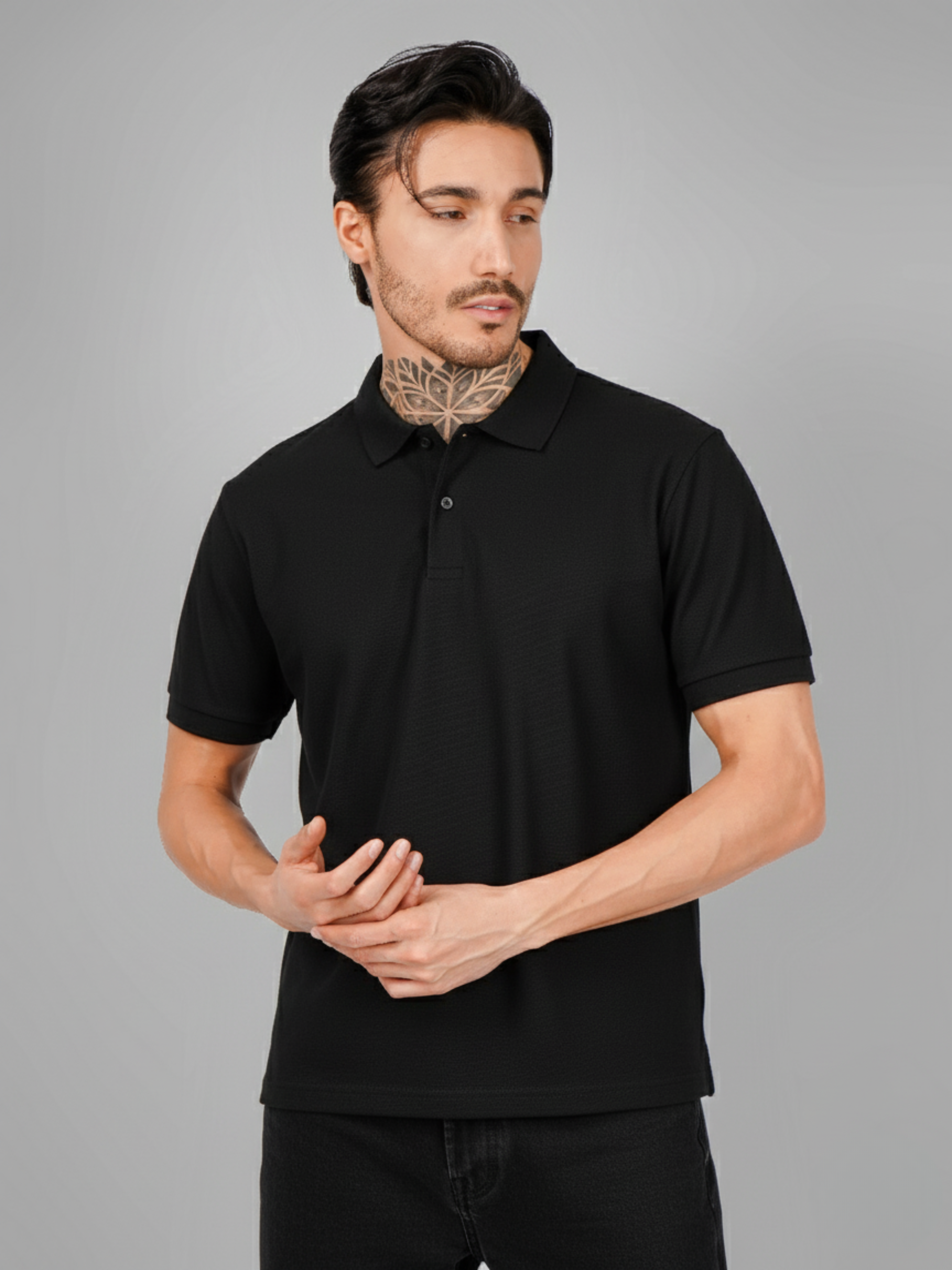 Man wearing a black polo shirt against a gray background