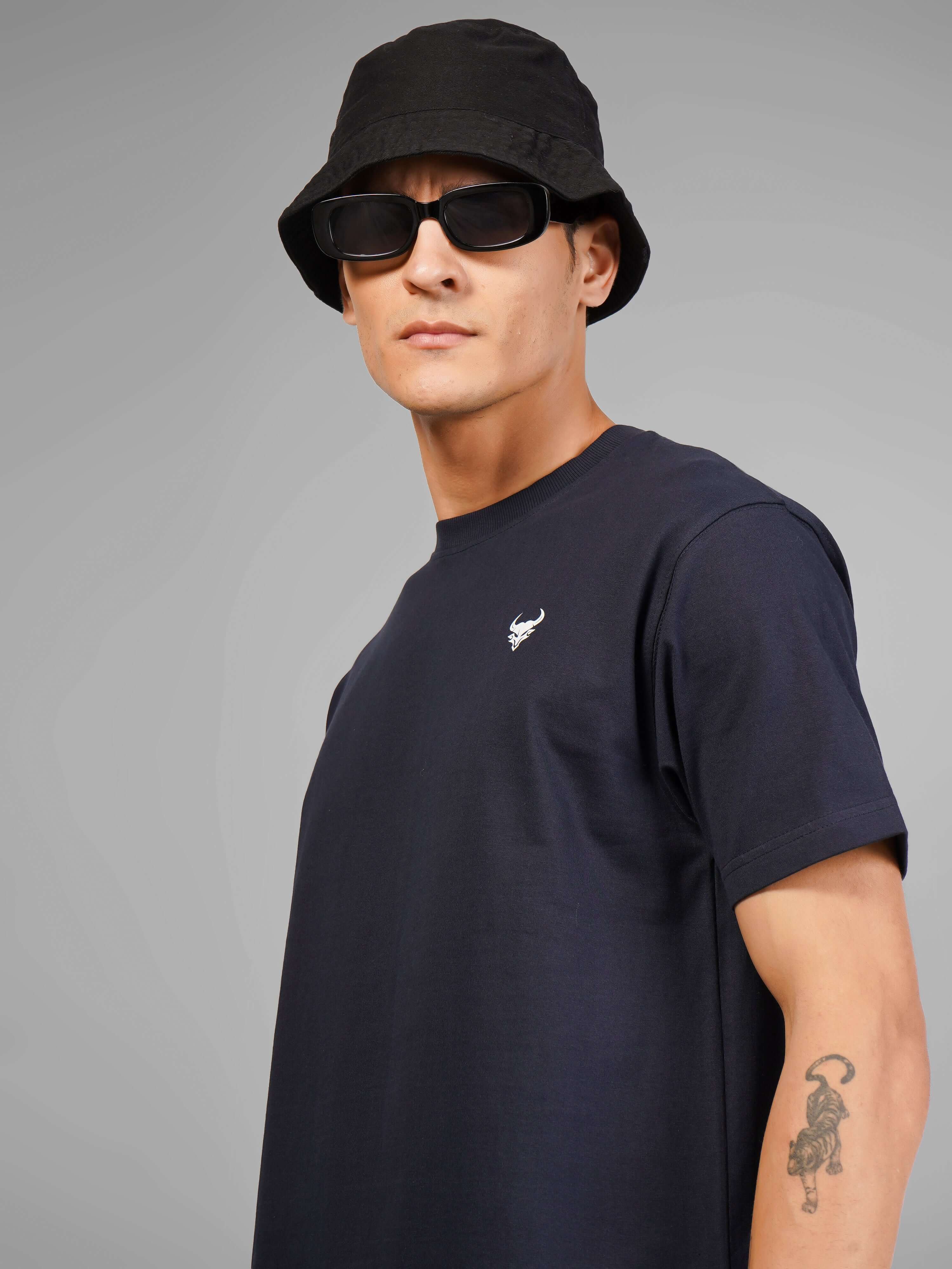 Man wearing The Skull Creature t-shirt with a black bucket hat and sunglasses, showcasing a minimalist design.