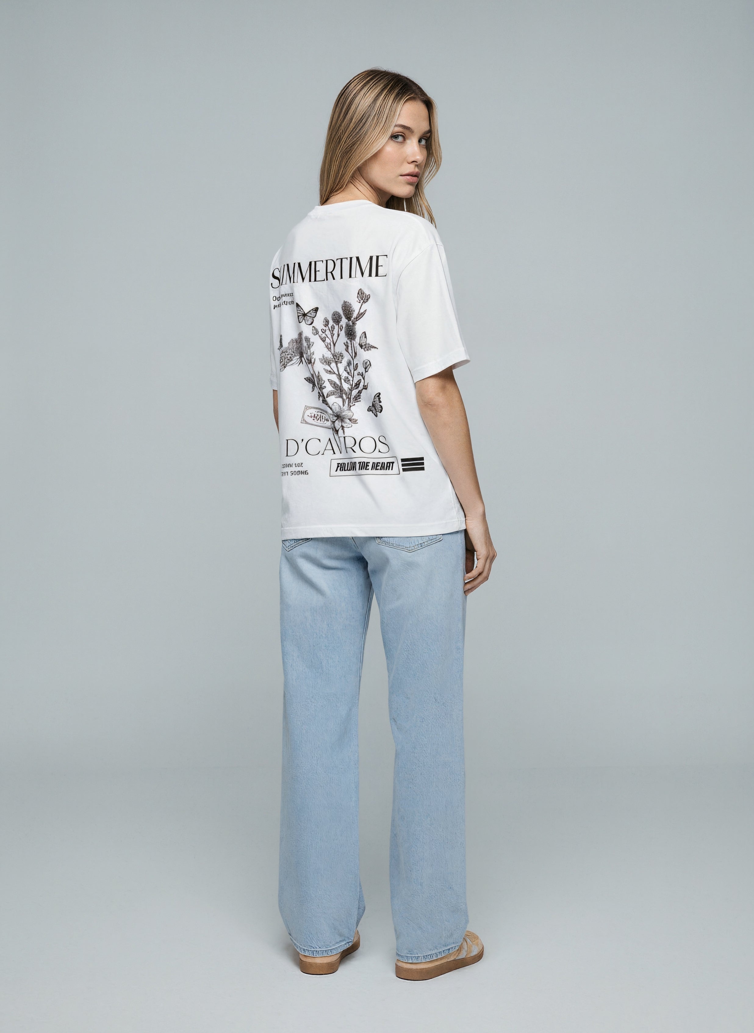 Back view of a model wearing an Oversized Graphics Printed T-Shirt featuring a bold summer time design.