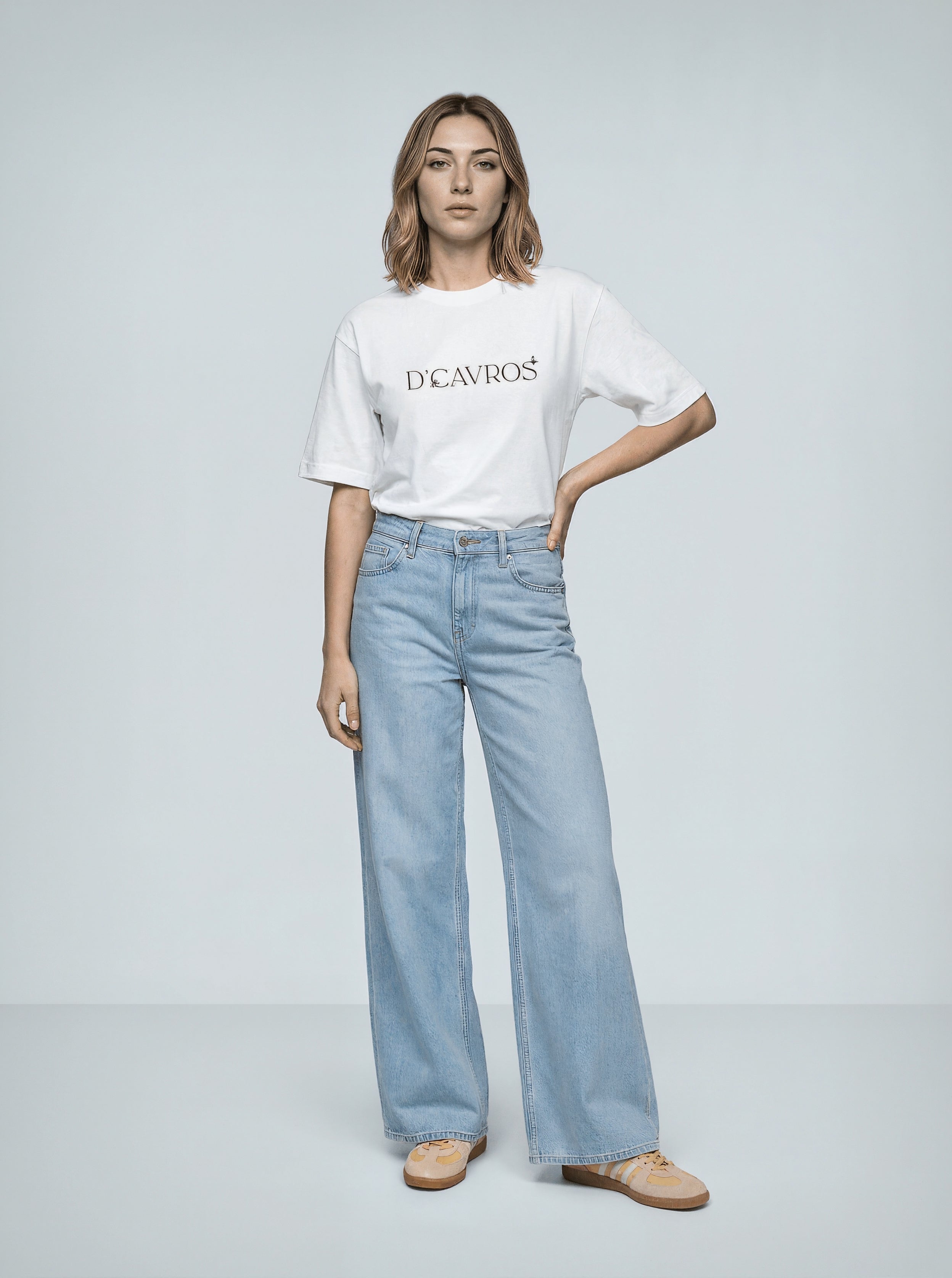 Model wearing an Oversized Graphics Printed T-Shirt with light blue jeans and tan shoes.