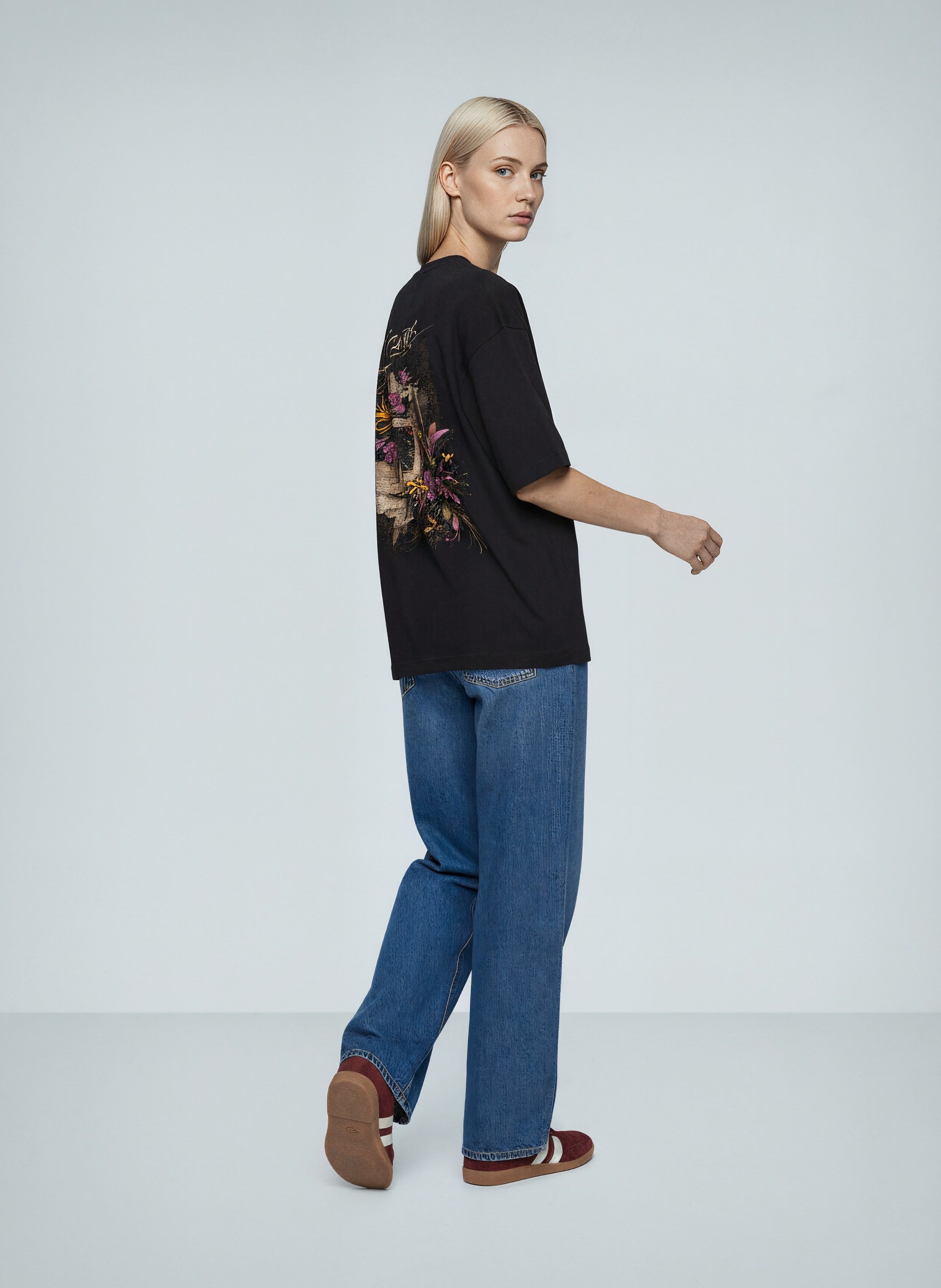 Oversized Printed-Frames T-Shirt worn by a model, featuring a floral frame back print and relaxed fit, styled with jeans.
