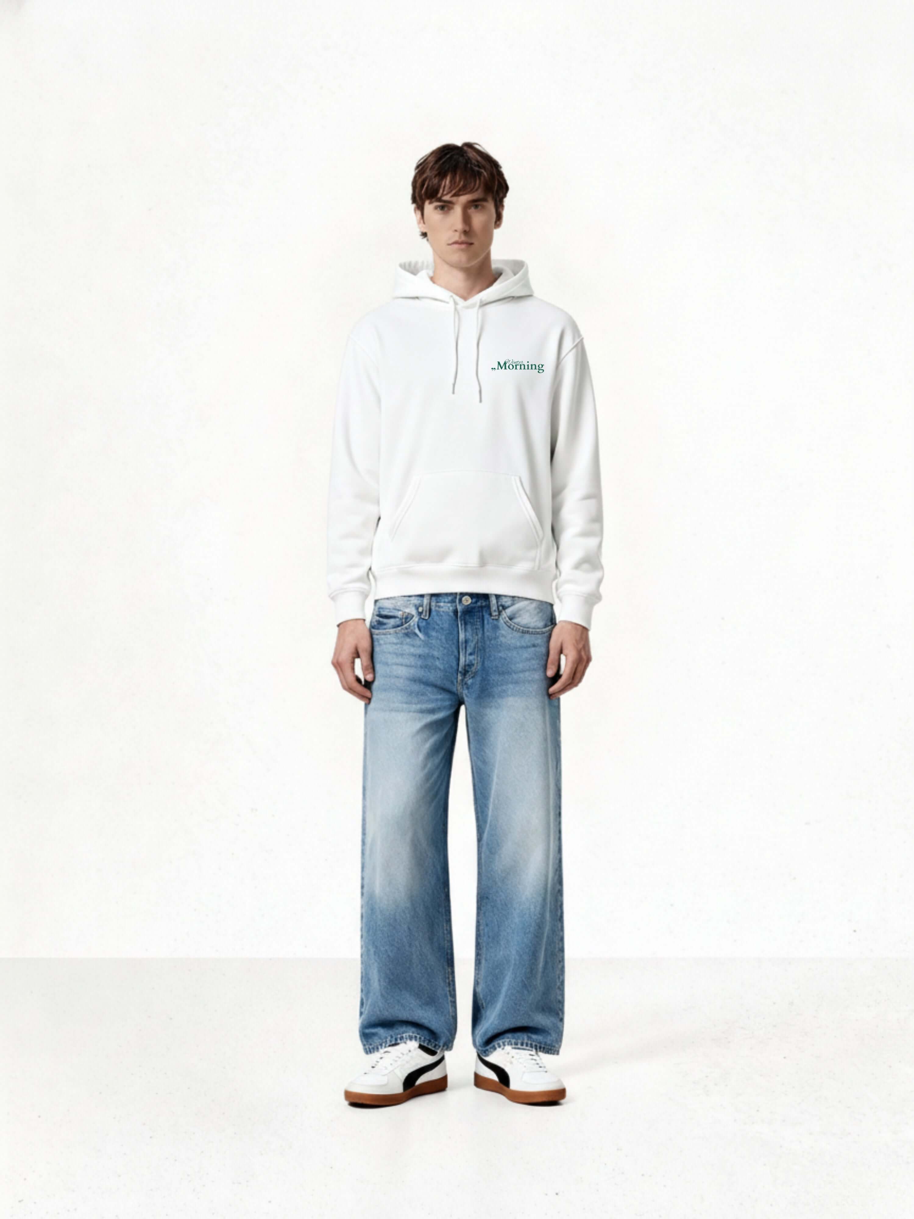 Model wearing a Winter Morning Unisex Hoodie and baggy jeans in a minimalist setting.