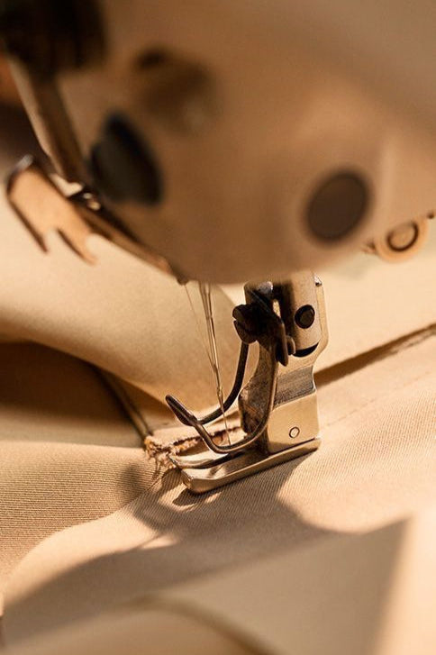 Close-up of a sewing machine needle in action on fabric.