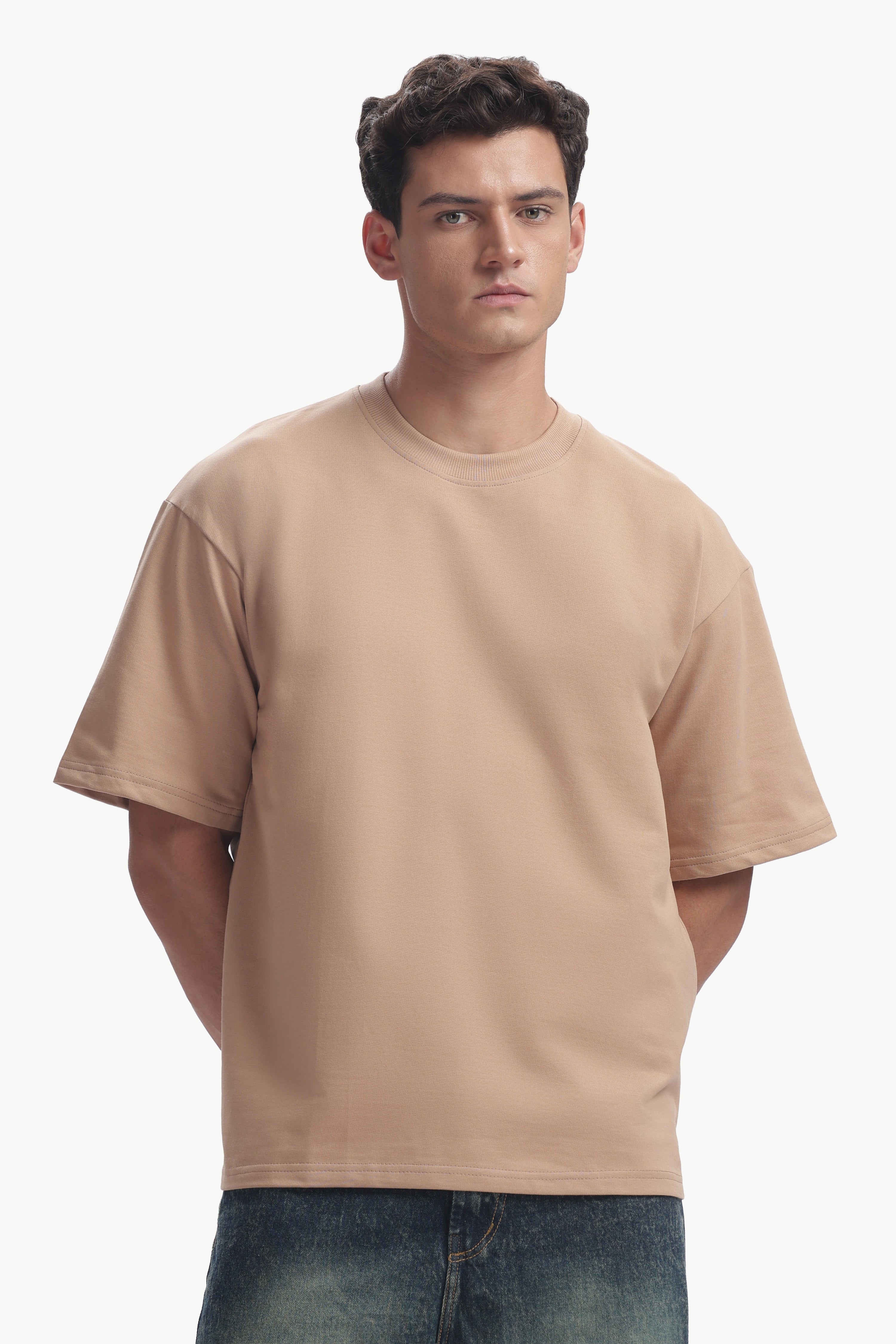 Model wearing an Oversized Fit Focal Point T-Shirt in a light tan color, showcasing relaxed silhouette and style.