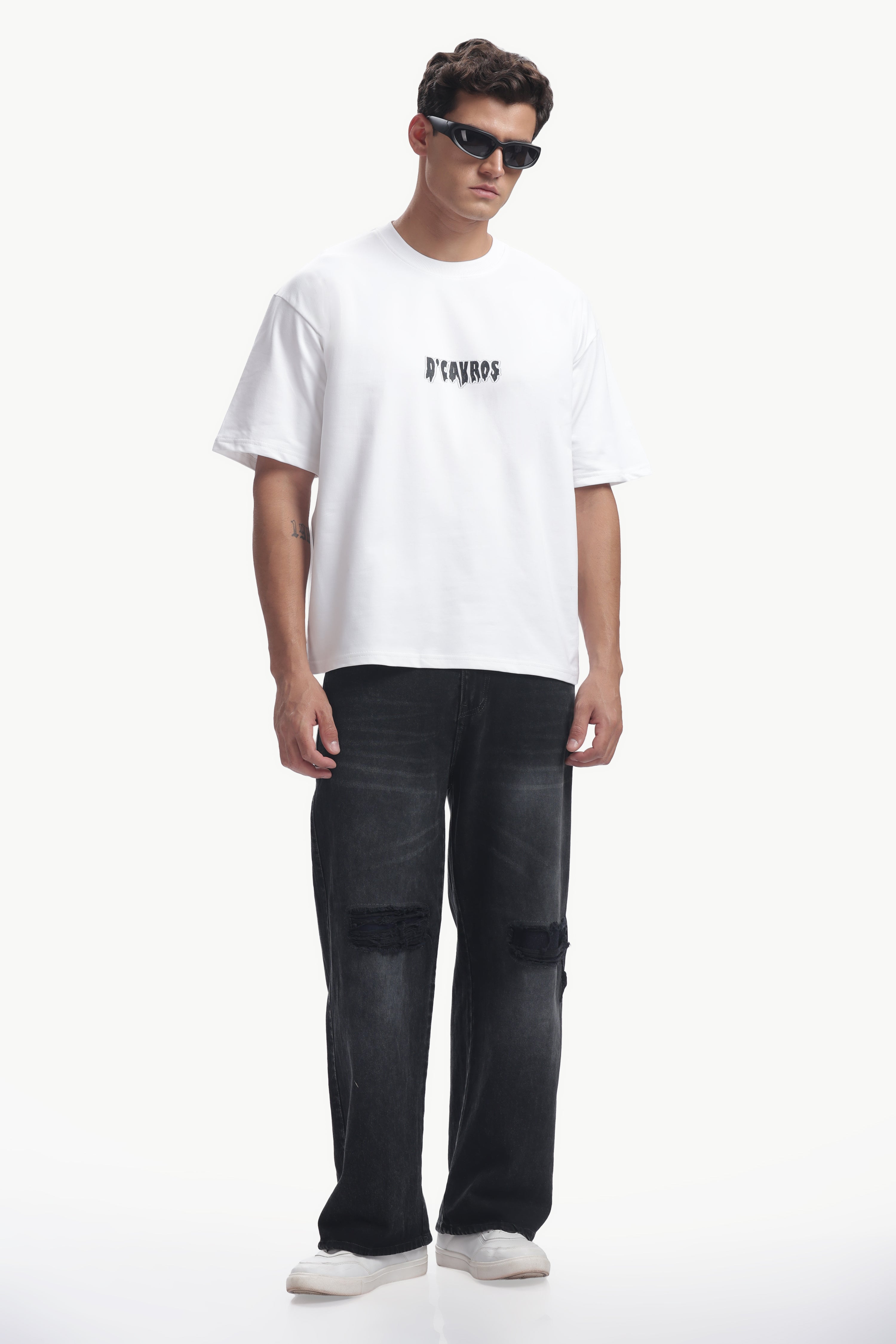 Model wearing Bad Guy Graphics Printed T-Shirt with relaxed fit and edgy design, paired with stylish black pants.