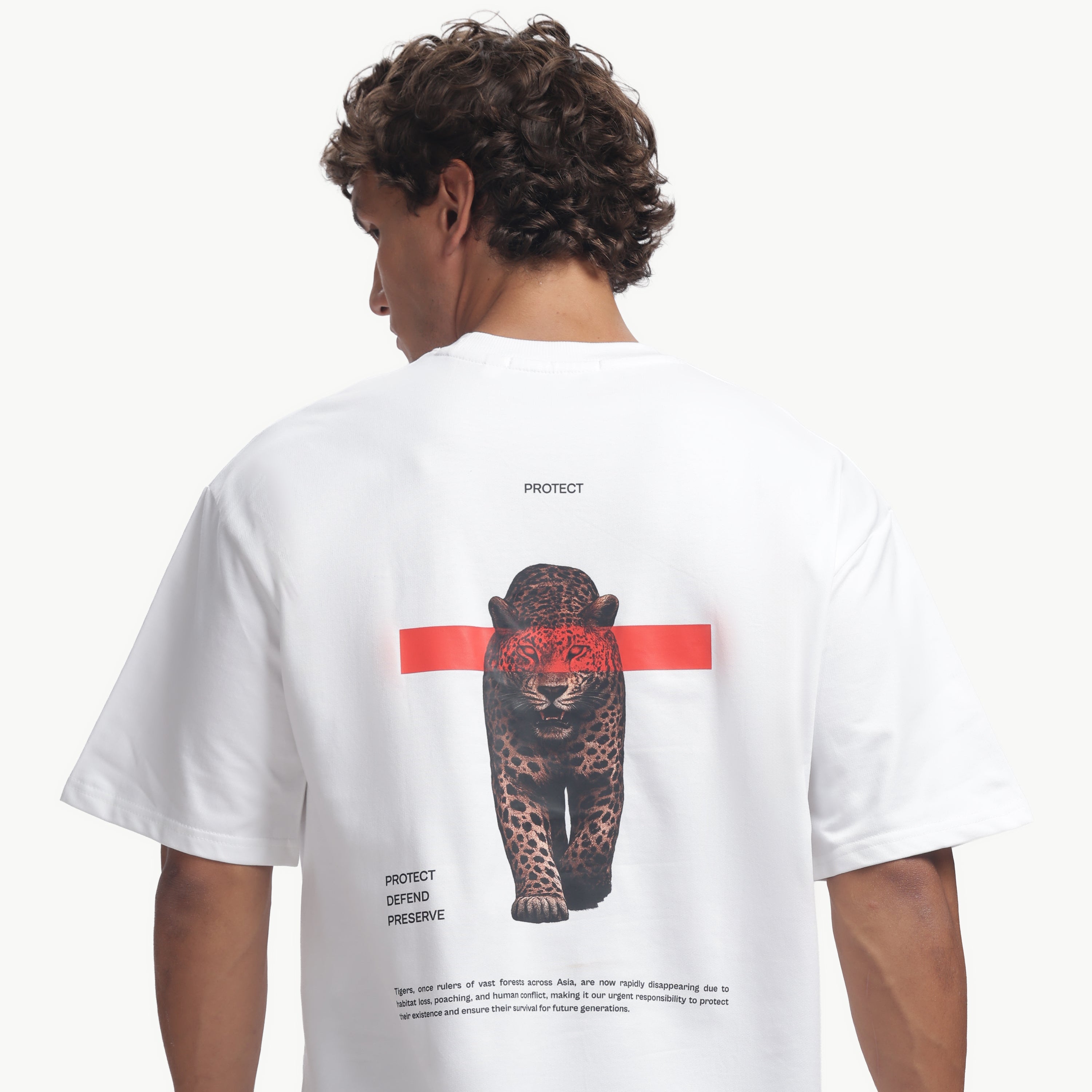 Person wearing a white t-shirt with a graphic design on the back, standing against a white background