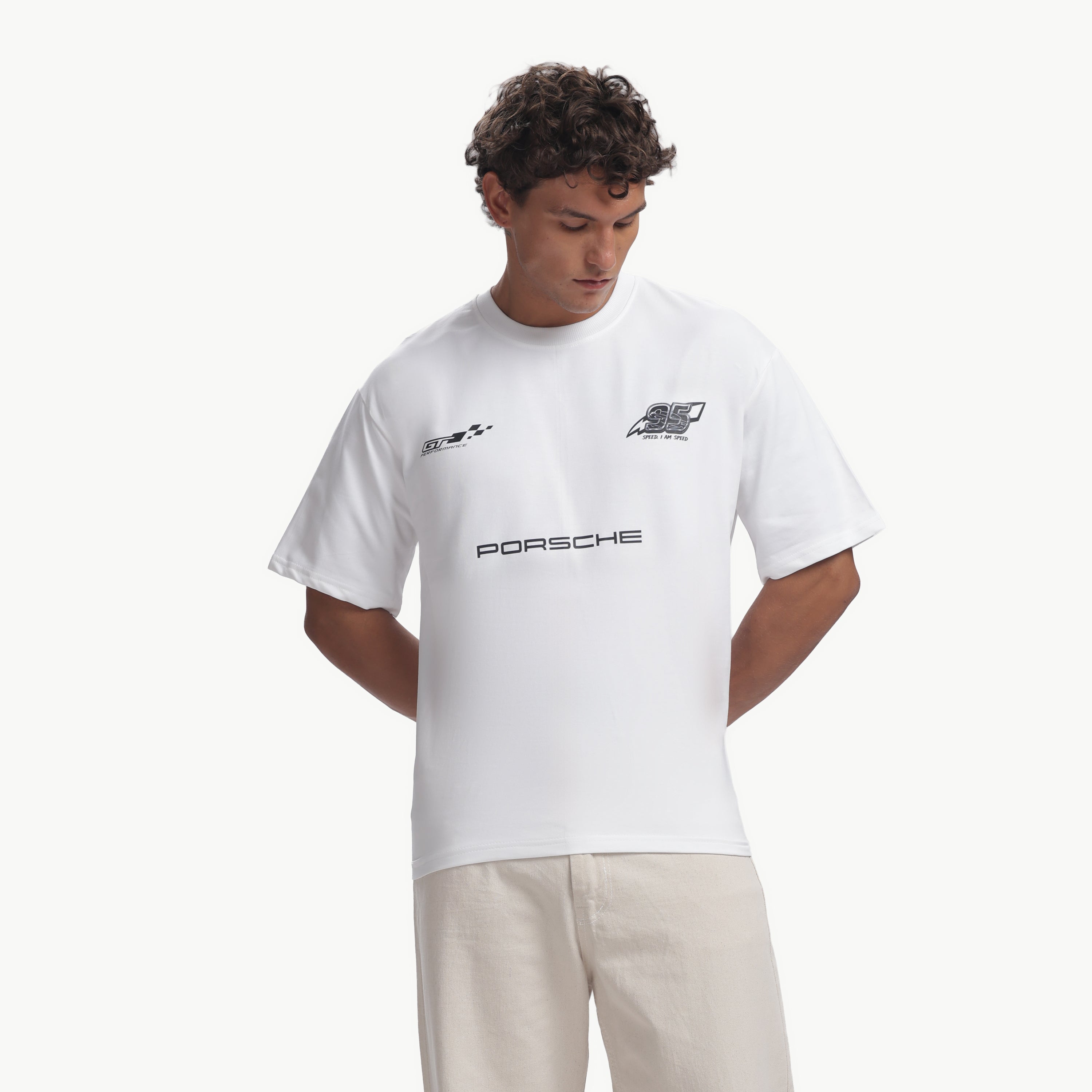 Person wearing a white Porsche t-shirt and beige pants on a white background