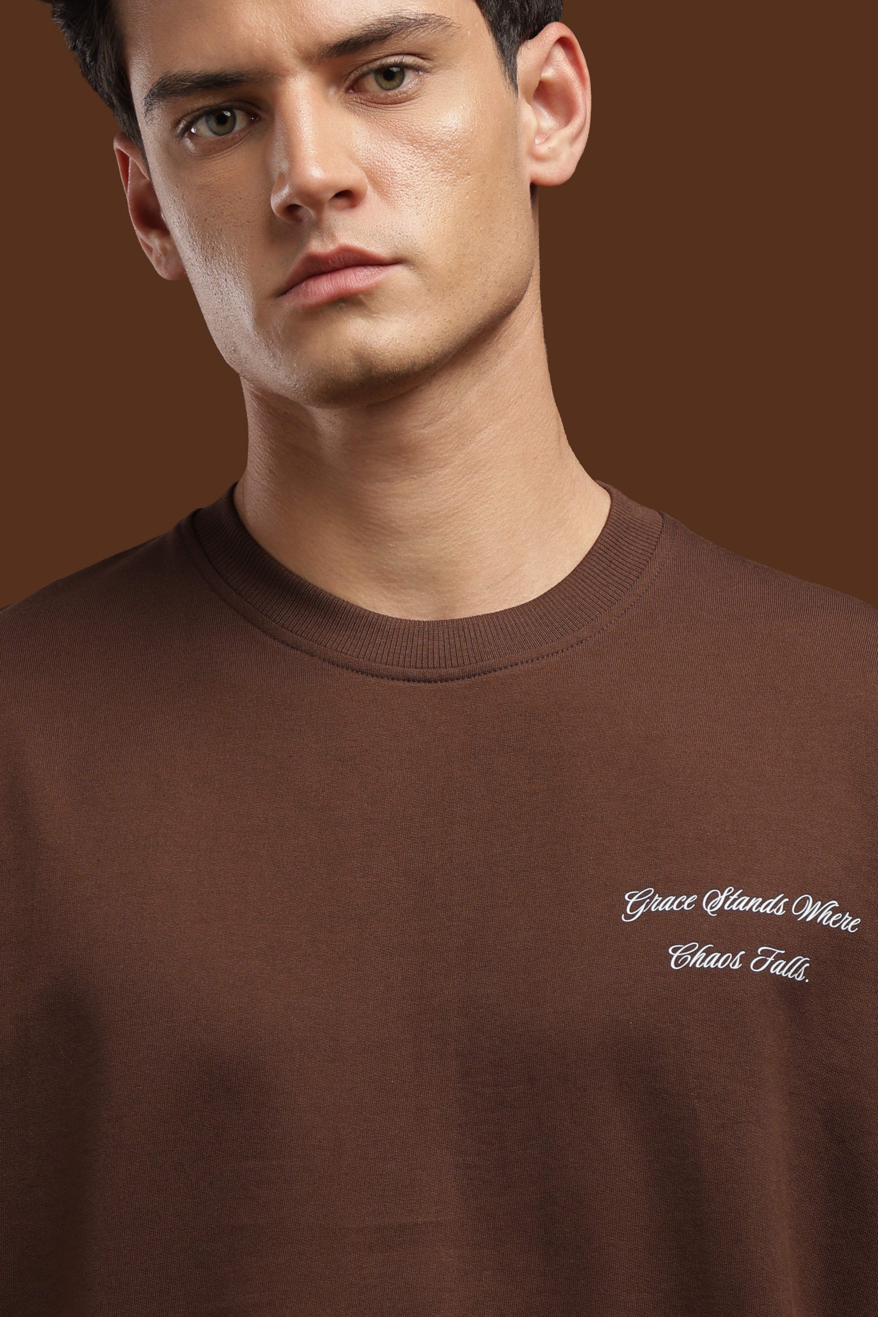 Oversized Fit Graphics Printed T-Shirt featuring a relaxed fit and unique graphic design on a brown background.