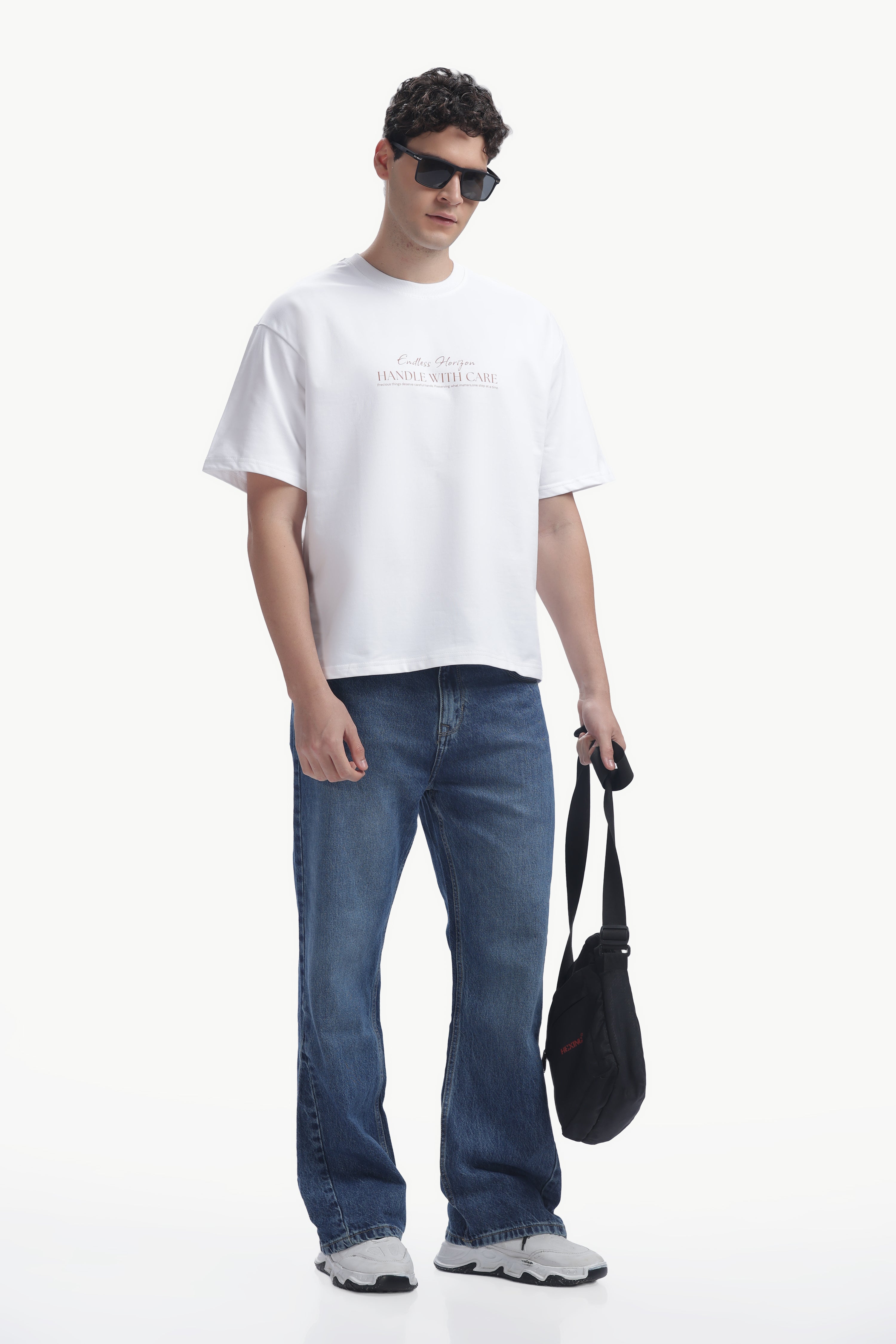 Model wearing a Vintage Horizon Printed T-Shirt with sunglasses and jeans, showcasing a casual summer look.