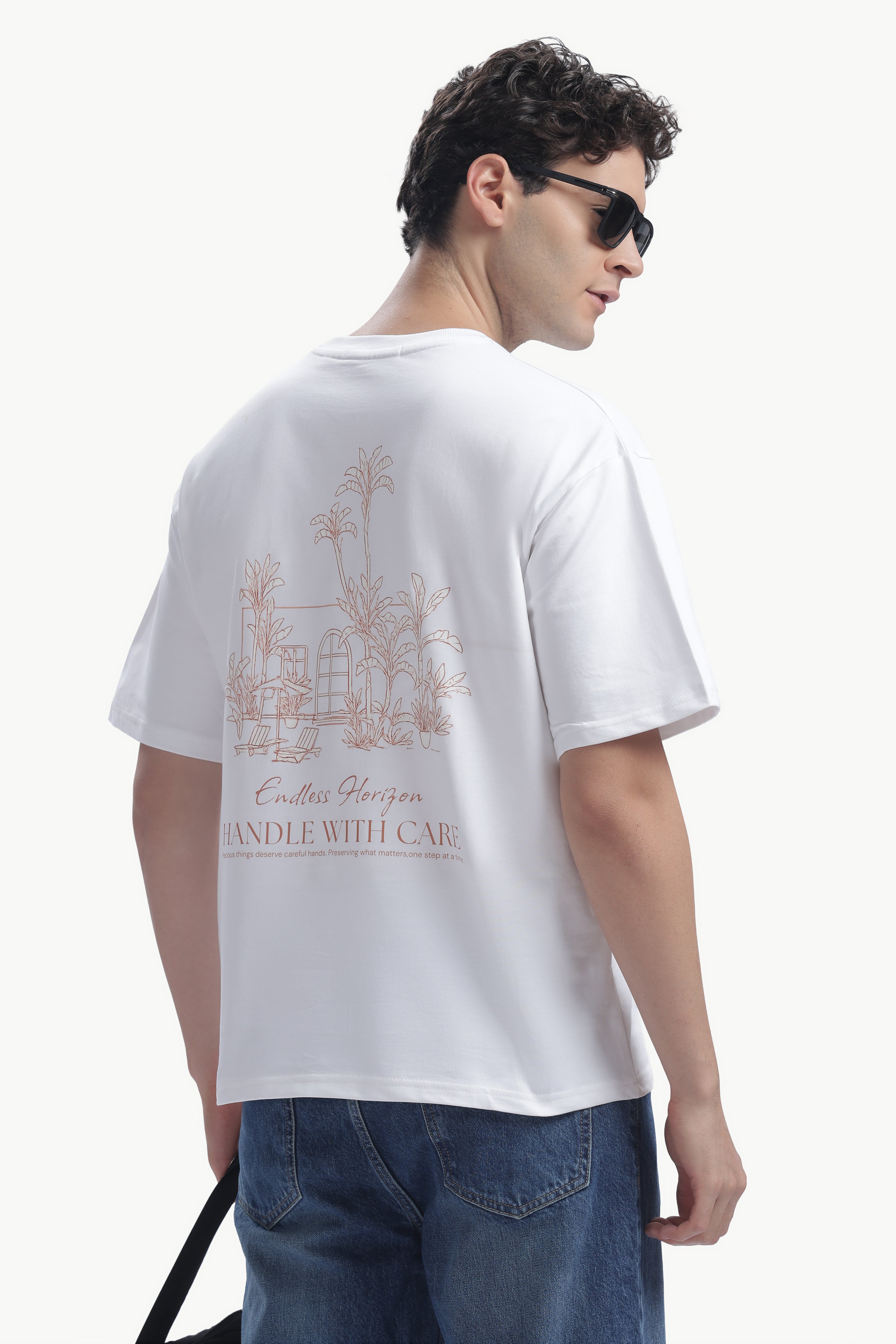 Model wearing Vintage Horizon Printed T-Shirt featuring minimalist palm artwork and relaxed fit.