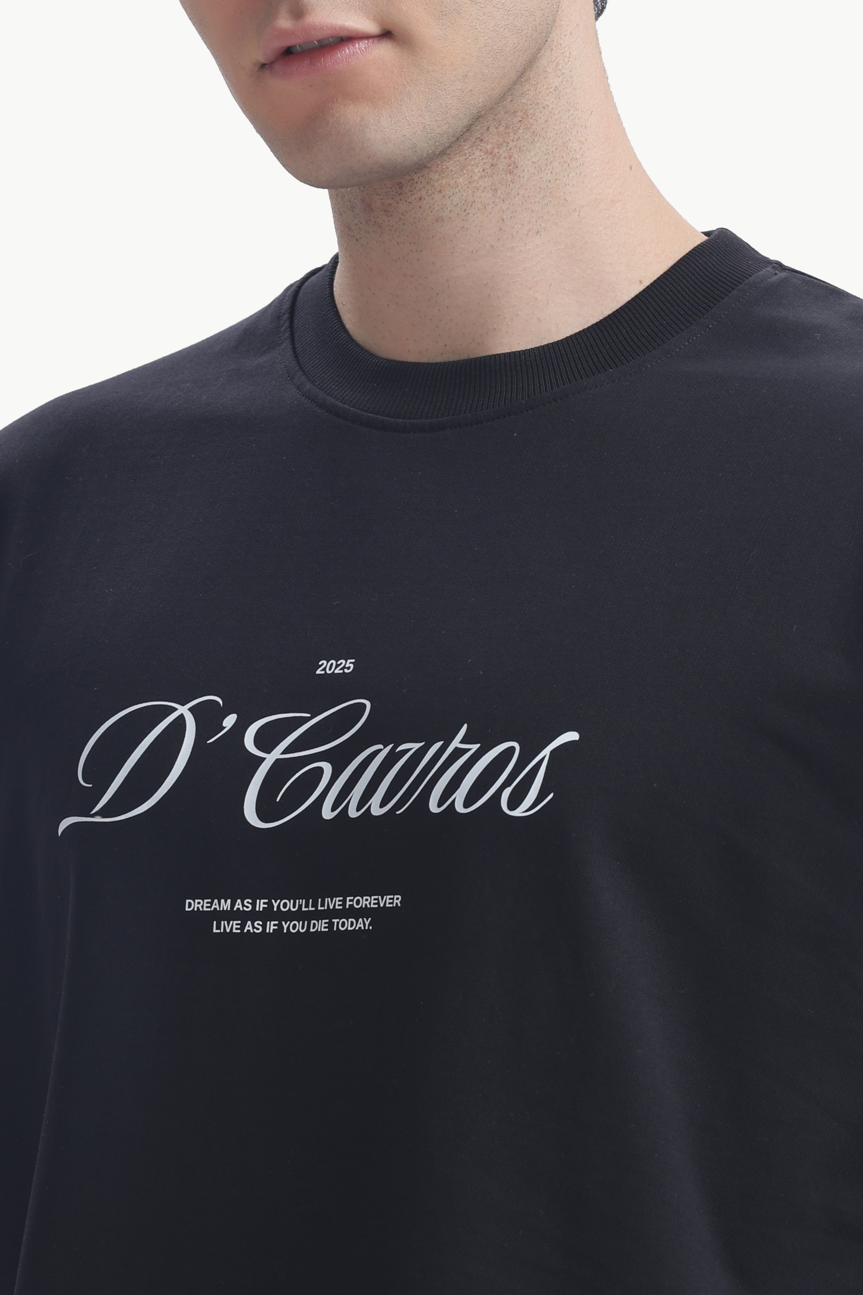 Close-up of a model wearing a Classic Loose Fit Typography T-Shirt with D'Cavros script design.